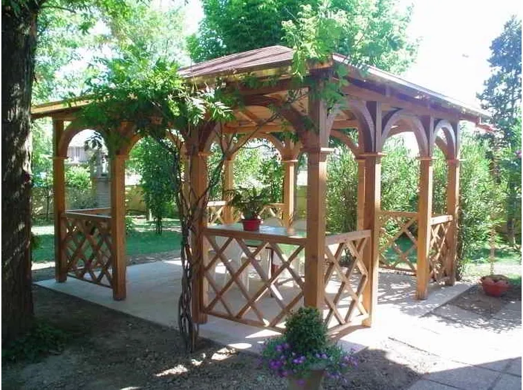 Un gazebo in legno all'ombra degli alberi