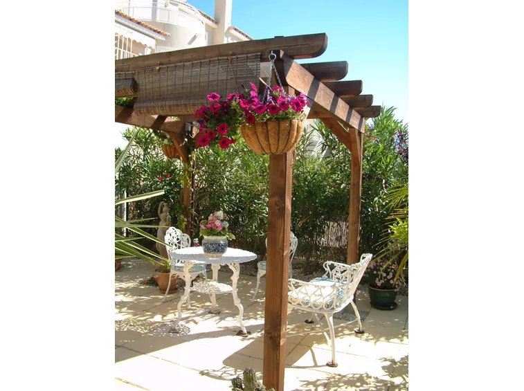 Una tettoia in legno adibita a salotto da esterno