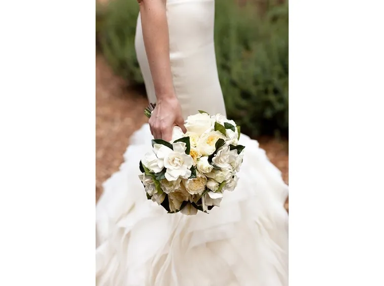 Bouquet di gardenie nelle mani di una sposa in bianco